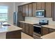 Gourmet kitchen with stainless steel appliances, quartz countertops, and dark wood cabinetry at 14647 Crestavista Dr, Clermont, FL 34714