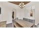 Dining room featuring a rustic wood table and an elegant chandelier, next to an archway to another room at 1518 Shadowmoss Cir, Lake Mary, FL 32746