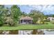 A rear view of a lovely home, featuring a screen enclosed patio, set against a tranquil pond backdrop at 1518 Shadowmoss Cir, Lake Mary, FL 32746