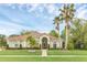 Charming single-story home featuring a tile roof, manicured lawn, and mature palm trees at 1518 Shadowmoss Cir, Lake Mary, FL 32746