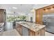 Gourmet kitchen featuring stainless steel appliances and an island with breakfast bar and an adjacent living area at 1518 Shadowmoss Cir, Lake Mary, FL 32746