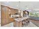 Modern kitchen featuring custom cabinetry, granite countertops, stainless steel appliances, and an island with bar stools at 1518 Shadowmoss Cir, Lake Mary, FL 32746