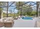 Inviting screened-in pool area with comfortable seating, waterfall features, and lush landscaping, ideal for outdoor entertaining at 1518 Shadowmoss Cir, Lake Mary, FL 32746
