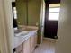 Neutral bathroom with a large mirror and a peach toned vanity at 1705 Betrillo Ct, The Villages, FL 32162