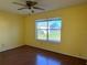 Bedroom featuring a window, a ceiling fan, and a wood-look floor at 1705 Betrillo Ct, The Villages, FL 32162