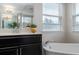 Bright bathroom featuring double windows, a soaking tub and modern vanity with decorative accents at 1710 Alejo Dr, Apopka, FL 32712