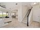 Inviting foyer featuring neutral tile flooring, a staircase, and an open layout flowing into the living and dining areas at 1710 Alejo Dr, Apopka, FL 32712