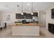 Bright kitchen features a large island with granite countertop and dark cabinetry at 1710 Alejo Dr, Apopka, FL 32712