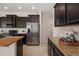 Kitchen with stainless steel refrigerator, granite counters, and dark cabinets at 1710 Alejo Dr, Apopka, FL 32712