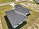 An aerial view showcases the gray shingled roof and green lawn surrounding this modern home at 17468 Sw 36Th Ter, Ocala, FL 34473
