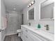 Bathroom featuring double vanity, large mirror and a walk-in shower with a marble tile surround at 17468 Sw 36Th Ter, Ocala, FL 34473