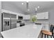 Bright kitchen featuring stainless steel appliances, white cabinets, and spacious quartz countertop island at 17468 Sw 36Th Ter, Ocala, FL 34473