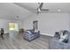 Open-concept living room has gray floors, ceiling fan, and sliding glass door at 17468 Sw 36Th Ter, Ocala, FL 34473