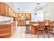Spacious kitchen with wood cabinets, tile flooring, and an island with bar seating at 2102 E Atmore Cir, Deltona, FL 32725