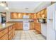 Well-lit kitchen featuring oak cabinetry, a white oven, and sleek countertops at 2102 E Atmore Cir, Deltona, FL 32725