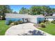 Charming single-story home featuring a blue brick exterior, well-maintained landscaping, and a paved driveway leading to the garage at 222 Paul Mcclure Ct, Casselberry, FL 32707