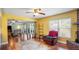 Spacious living room featuring a brick fireplace, hardwood floors, and an open layout leading to the kitchen and dining area at 222 Paul Mcclure Ct, Casselberry, FL 32707