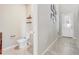 Modern half bathroom featuring tile floors, floating shelves, and neutral gray walls at 2412 Gold Dust Dr, Clermont, FL 34715