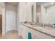 Bright bathroom featuring double granite vanity, framed mirror, and neutral tile flooring at 2412 Gold Dust Dr, Clermont, FL 34715