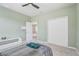 A cozy bedroom with pale green walls features a ceiling fan and carpeted floors at 2412 Gold Dust Dr, Clermont, FL 34715