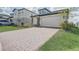 Paver driveway leading to a well-maintained two-story home with stone accents at 2412 Gold Dust Dr, Clermont, FL 34715