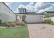Charming two-story home with manicured lawn, brick driveway, and stone pillar accents at 2412 Gold Dust Dr, Clermont, FL 34715