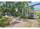 Lush backyard with a pink chair, mature trees and screened in lanai at 2515 Wekiva Walk Way, Apopka, FL 32703