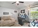 Bedroom has a comfy couch, desk setup, and lots of natural light from the window at 2515 Wekiva Walk Way, Apopka, FL 32703