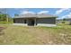 Exterior shot of the backyard with a covered patio, lawn, and lush grass at 2808 Sw 139Th St, Ocala, FL 34473