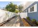 Side yard featuring a well-maintained walkway bordered by lush landscaping and a white fence, adding charm to the property at 2945 Southgate Ter, Orlando, FL 32818