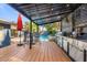 Inviting outdoor kitchen featuring a grill, counter space, a dining table, and a view of the pool, perfect for entertaining at 2945 Southgate Ter, Orlando, FL 32818
