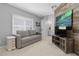 Bedroom featuring barnwood wall, gray sofa, shutters and a TV at 306 Balfour Dr, Winter Springs, FL 32708