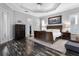 Main bedroom with tray ceiling, dark wood floors, and access to an en-suite bathroom and walk-in closet at 306 Balfour Dr, Winter Springs, FL 32708