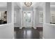 Elegant foyer with dark wood floors, chandelier lighting, decorative leaded glass door and bright interior at 306 Balfour Dr, Winter Springs, FL 32708