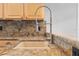 Close-up of kitchen sink featuring granite countertops and a modern stainless steel faucet fixture at 306 Balfour Dr, Winter Springs, FL 32708