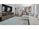 Open-concept living room with modern entertainment center and seamless flow into the kitchen at 306 Balfour Dr, Winter Springs, FL 32708