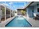 Private pool area with sparkling blue water, surrounded by a screened enclosure and lush landscaping at 306 Balfour Dr, Winter Springs, FL 32708