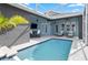 A covered patio area features a cozy dining table and two lounge chairs next to a refreshing in-ground swimming pool at 306 Balfour Dr, Winter Springs, FL 32708