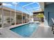 Inviting screened-in pool area, perfect for relaxing and entertaining with a tropical garden and blue water at 306 Balfour Dr, Winter Springs, FL 32708