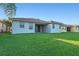 Backyard featuring lawn, covered patio, and house exterior with neutral tones at 307 Monterey St, Kissimmee, FL 34759