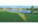 Picturesque view of a serene lake surrounded by lush green grass and neighborhood homes at 307 Monterey St, Kissimmee, FL 34759