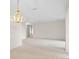 Bright, carpeted living room featuring a stylish gold chandelier and neutral paint at 307 Monterey St, Kissimmee, FL 34759