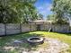 Lush backyard with a stone fire pit and a wooden fence, perfect for outdoor gatherings at 3150 Sawgrass Ct, Kissimmee, FL 34746