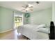 Light, bright bedroom featuring a ceiling fan, large window, and mounted television at 3150 Sawgrass Ct, Kissimmee, FL 34746