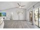 Bright living room featuring modern flooring, neutral tones, and seamless access to the outdoor pool area at 3150 Sawgrass Ct, Kissimmee, FL 34746