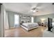 Spacious main bedroom featuring wood floors, a king-sized bed, and ample natural light from large windows at 3150 Sawgrass Ct, Kissimmee, FL 34746