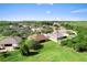 An aerial view shows the rear of the home backing up to a greenbelt, surrounded by lush trees and well-kept lawns at 3281 Pawleys N Loop, St Cloud, FL 34769