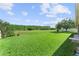 The spacious backyard has lush green grass, trees and a view of a beautiful blue sky at 3281 Pawleys N Loop, St Cloud, FL 34769