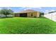 Spacious backyard with healthy green grass, white vinyl fencing, and a screened-in lanai at 3281 Pawleys N Loop, St Cloud, FL 34769