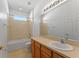 Neutral bathroom features a tub-shower combo, a framed mirror, and a single sink vanity at 3281 Pawleys N Loop, St Cloud, FL 34769